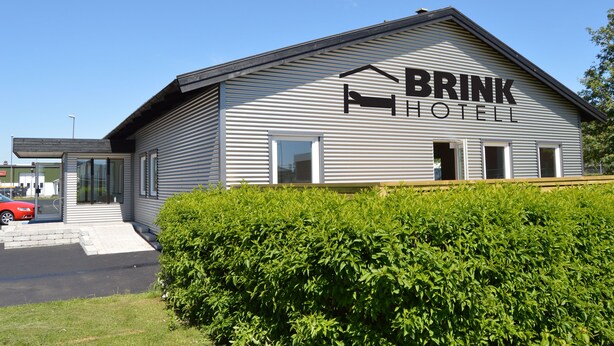 A BRINK HOTEL building with a modern design, featuring a large entrance and a clear view of the parking area. - Brink Hotell (Eslöv)