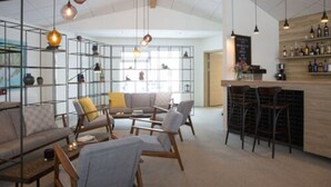 A modern interior with a bar area, seating arrangement, and a visible wine rack. - Hotel Gullfoss (Bláskógabyggd)