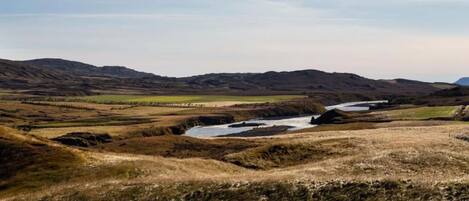 Un paisaje extenso con colinas ondulantes y un río.