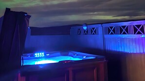 A room with a view of the northern lights, a hot tub, and a staircase. - Hotel Gullfoss (Bláskógabyggd)