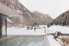 Una piscina cubierta, una piscina al aire libre, tumbonas