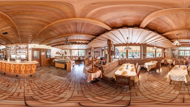 A spacious restaurant with a curved wooden ceiling, a central bar area, and multiple dining tables. - Hotel Sonnhof (Radfeld)