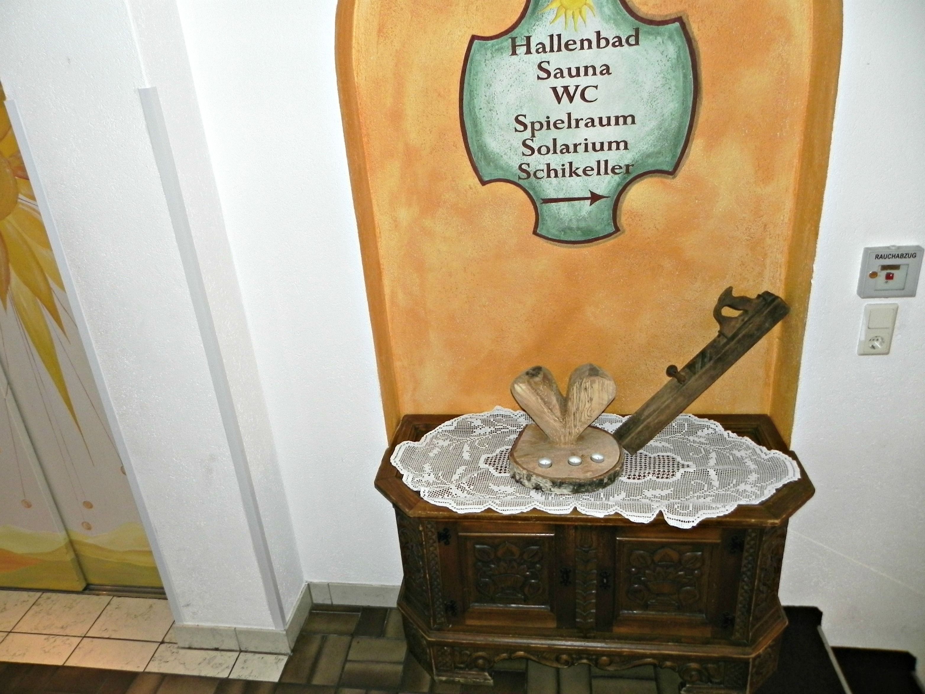 Ein Holzkabinent mit einer Spitzendecke und rustikaler Dekoration, an einer Wand mit einem Schild darüber platziert.