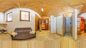 A room with a curved ceiling, a wooden bench, a glass shower enclosure, and a wooden sauna. - Hotel Sonnhof (Radfeld)