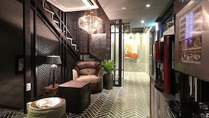 A modern interior with a leather sofa, a small table, and a potted plant. - 25 Hours Hotel (Busan)