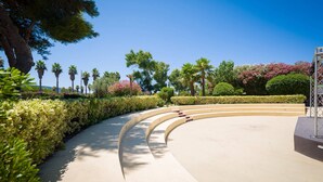 A curved pathway flanked by neatly trimmed hedges and trees, leading to a building with a modern architectural design. - Borgo del Principe by Valentour (Zambrone)