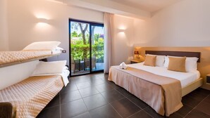 A hotel room with a bed, a sofa bed, a small table, a nightstand, and a sliding glass door leading to a balcony. - Borgo del Principe by Valentour (Zambrone)