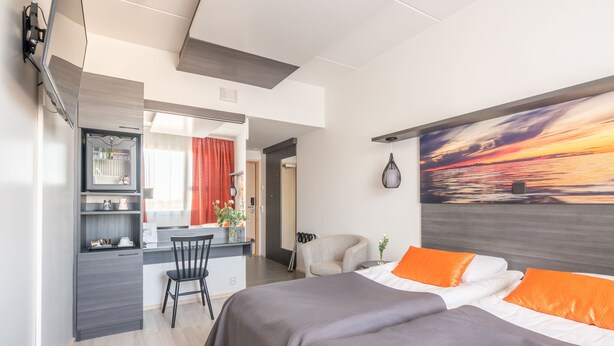 A modern hotel room with a bed, a desk, and a chair. - Hotel Raahen Hovi (Raahe)