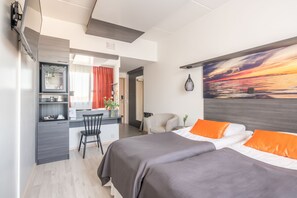 A modern hotel room with a bed, a desk, and a chair.