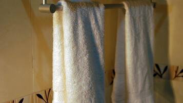 Un bagno con un portasciugamani che contiene diversi asciugamani piegati.