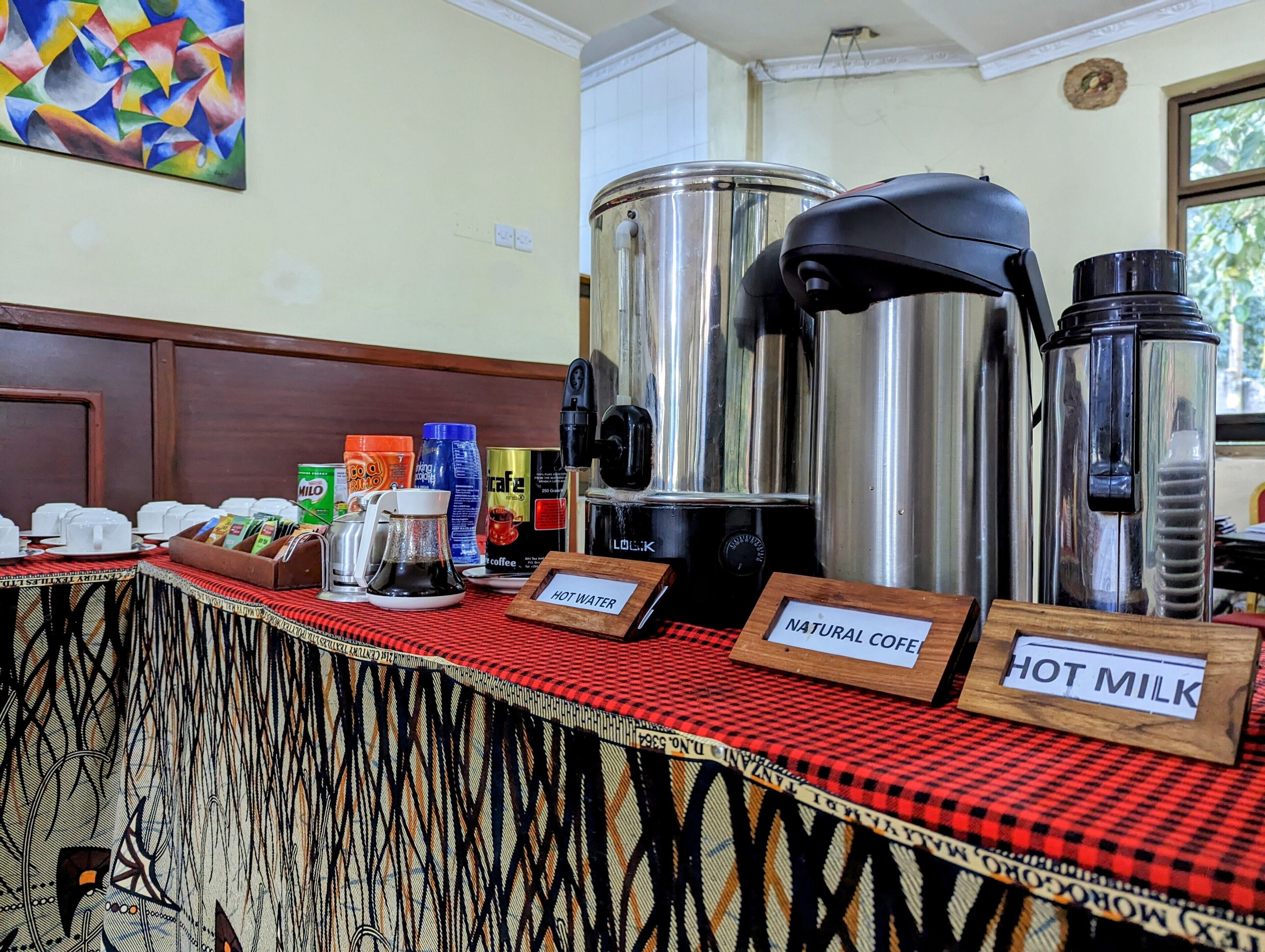 Un buffet proposant du café, du thé et du lait chaud, ainsi qu’une machine à café et un distributeur d’eau chaude.