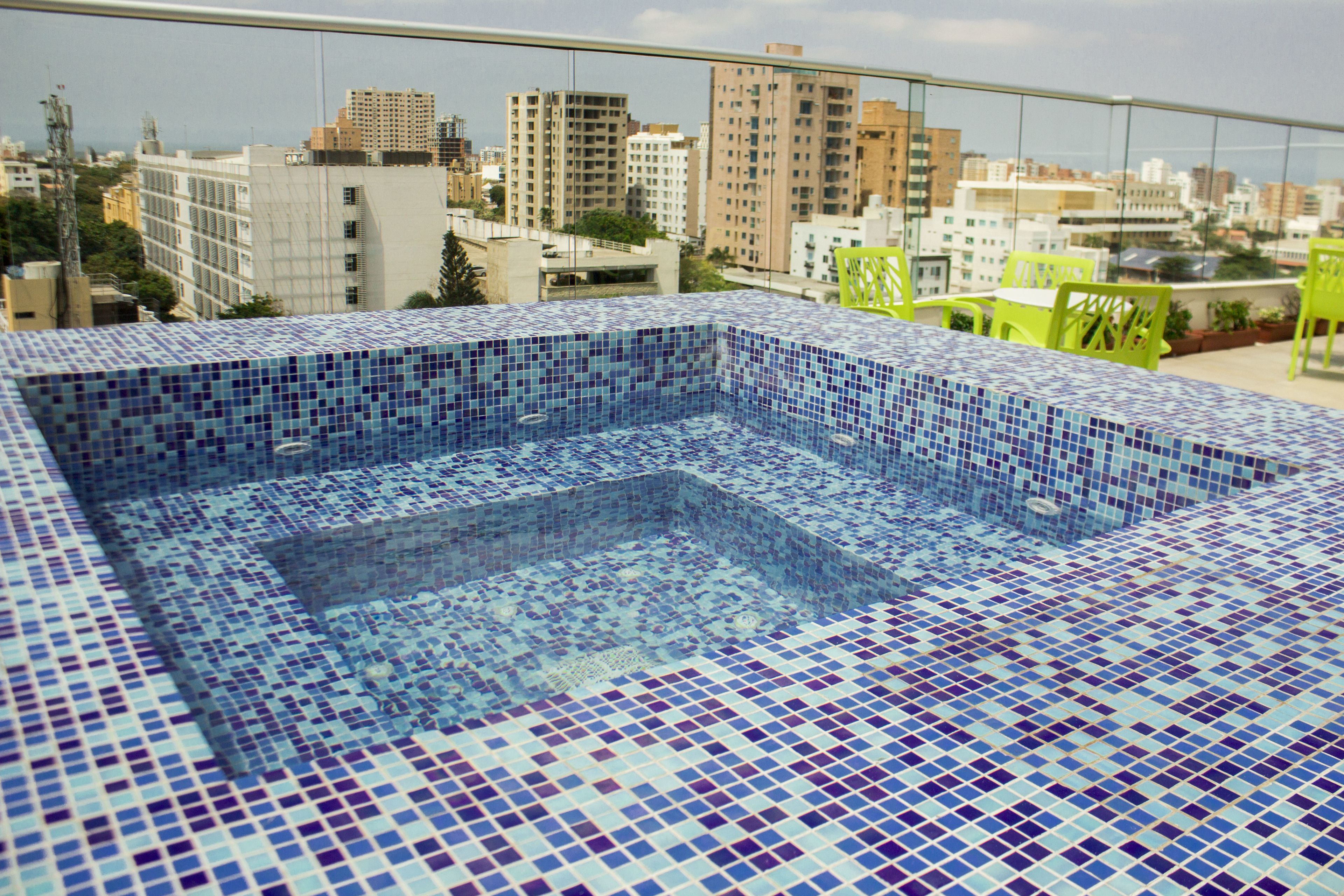 A rooftop swimming pool with a cityscape view.