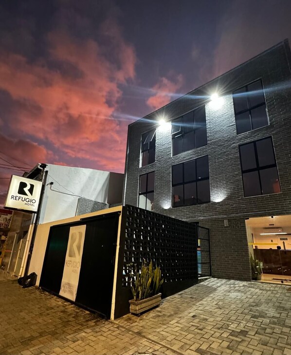 Refugio Hotel offers a contemporary lodging experience with a brick and glass design.