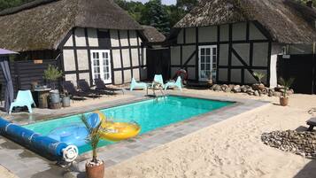 Kauden mukainen ulkouima-allas, aurinkotuoleja