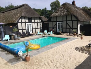 Una piscina al aire libre de temporada, sillones reclinables de piscina