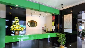 A reception desk with a green counter, a sign reading "Parkland Hotel," and a potted plant. - Parkland Hotel (Brinchang)
