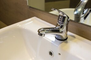 Tweepersoonskamer | Badkamer | Een douche, een haardroger, een bidet, handdoeken