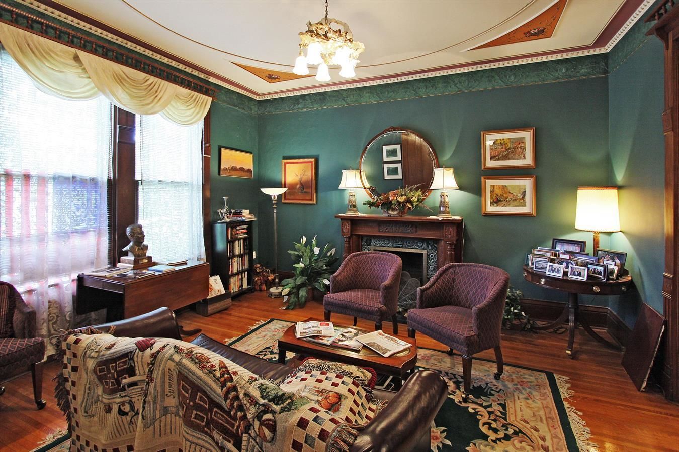 Un salon traditionnel avec une cheminée, deux fauteuils, un canapé et une table basse.