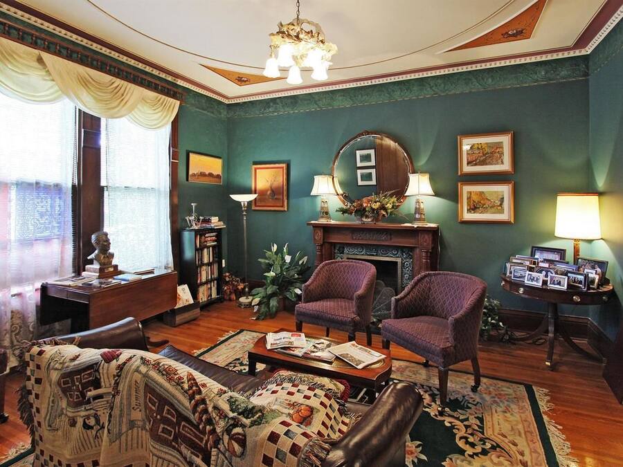 Uma sala de estar tradicional com lareira, dois poltronas, um sofá e uma mesa de centro.