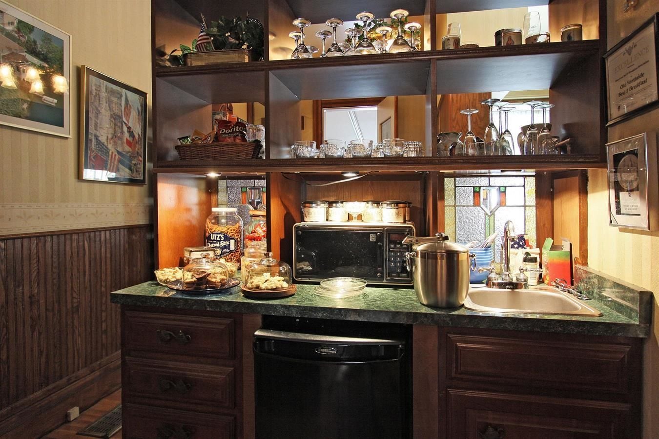 A kitchen with a built-in oven, a sink, and various food items on the counter.