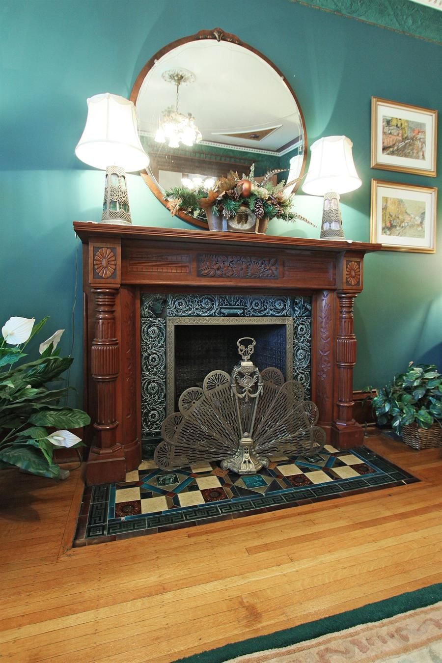 A fireplace with a decorative mantel, a mirror above it, and a patterned rug in front.