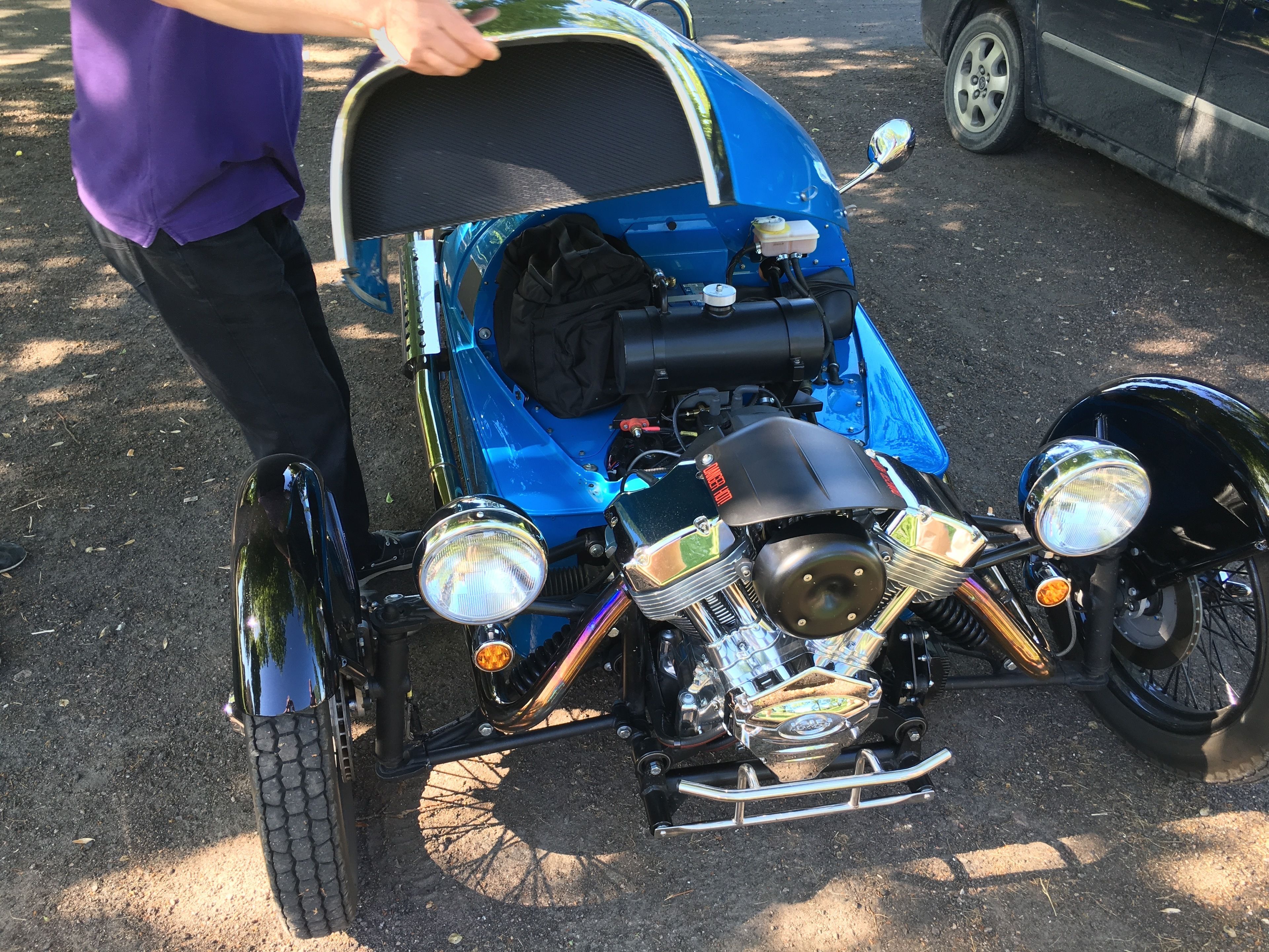 A custom motorcycle with a blue body, chrome accents, and a black seat.