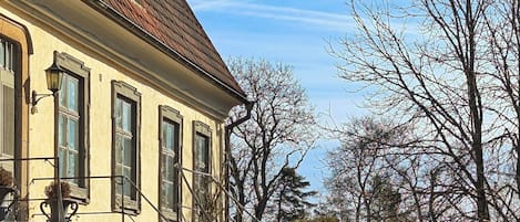 A building with a staircase leading to a door, surrounded by trees and a clear sky.