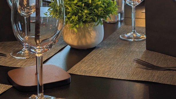 A dining table set with wine glasses, a potted plant, and a lamp. - Brunsbo G:a Biskopsgård Hotell & Konferens (Skara)