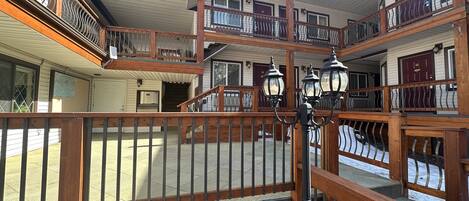 A multi-story building with balconies, wooden railings, and a central staircase.