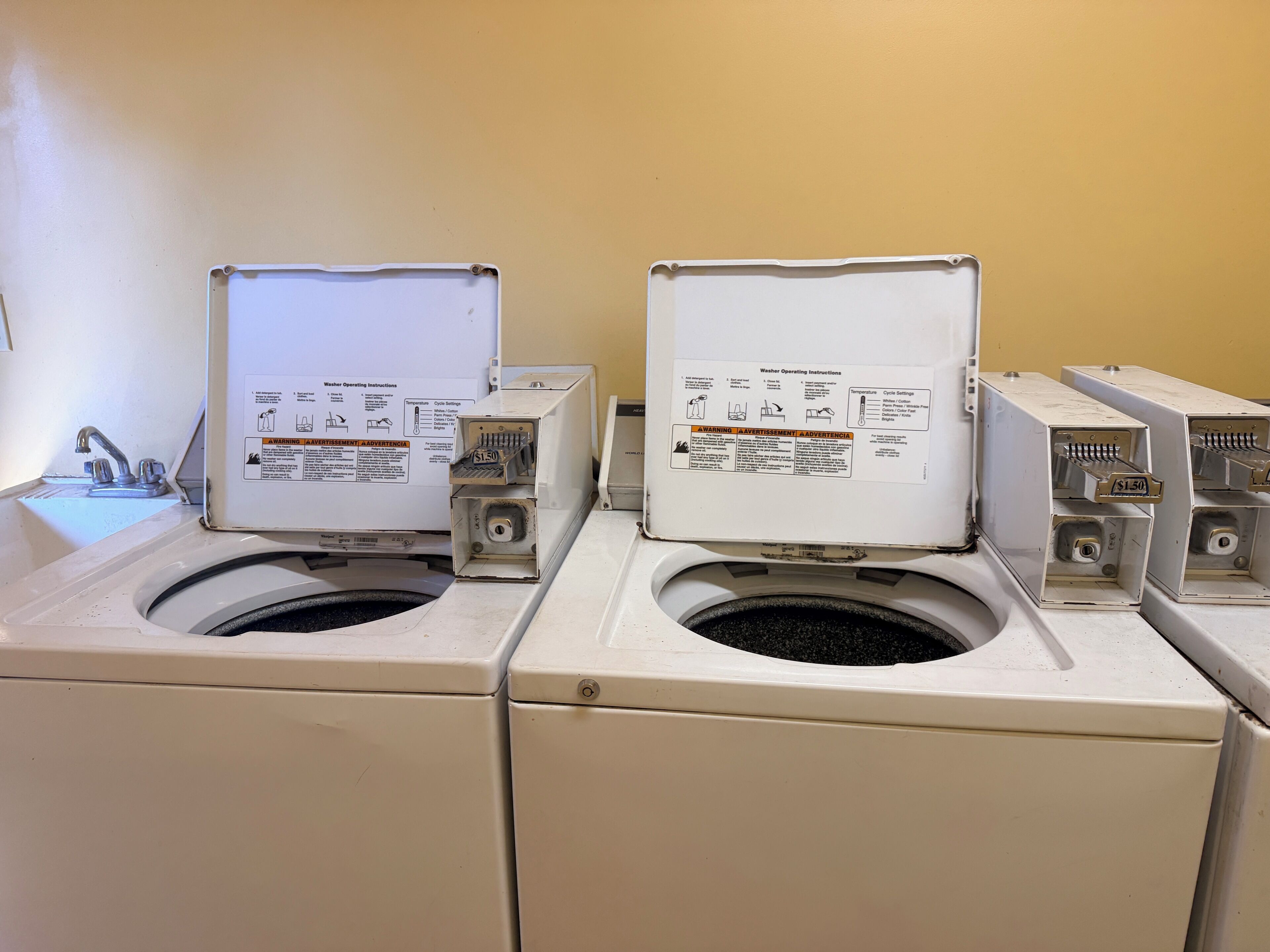 A laundry area with two washing machines and a sink.