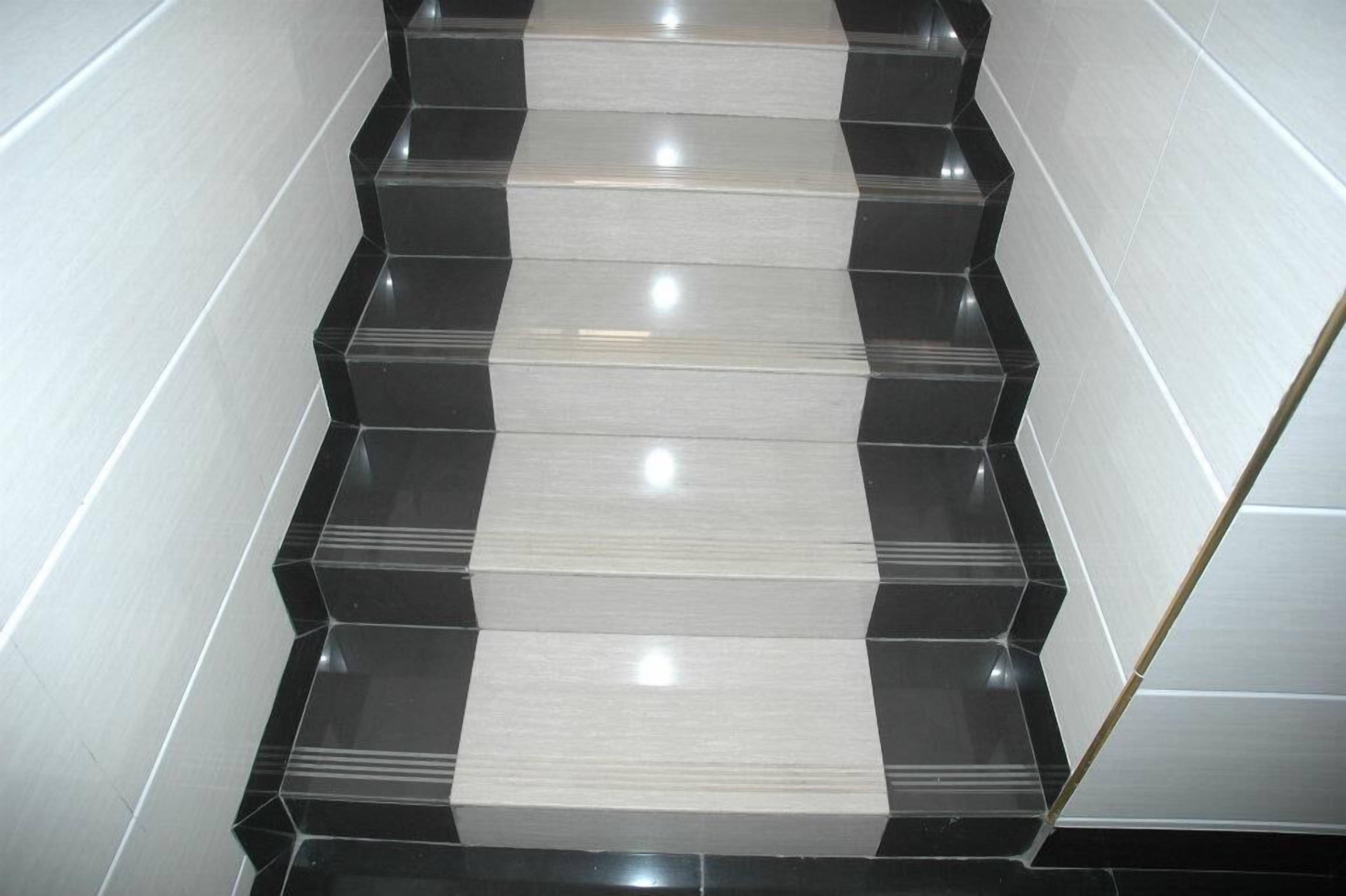 Un escalier carrelé en noir et blanc, situé dans un bâtiment.