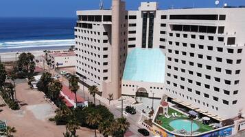 Enjoy ocean views from this high-rise hotel's rooftop pool area, surrounded by palm trees and a landscaped pool deck.