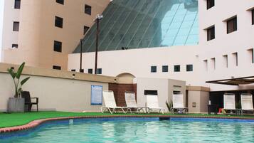 Una piscina al aire libre, sombrillas, tumbonas