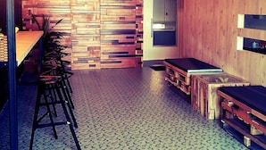 Un interior de restaurante moderno con una barra larga, varios taburetes y un suelo con diseño.
