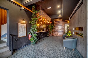 Een modern interieur met een bar, zitplaatsen en decoratieve planten.