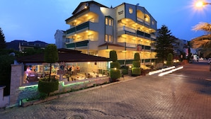 A multi-story hotel with balconies, a bar, and a well-lit entrance. - Amaris Apartments (Marmaris)