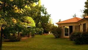 A house with a red-tiled roof, a front door, and a small porch area. - Angelo di Caneva (Chacras de Coria)