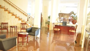 A spacious lobby with a polished marble floor, a staircase with wooden railings, and a zebra statue. - Nyumbani Hotels & Resorts - Moshi (Moshi)