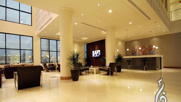 A spacious lobby with a reception desk, seating area, and large windows. - Rafa Homes  (Riyadh)