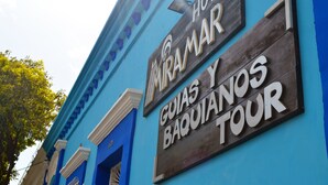 A hotel sign with "Hôtel Miramar" and "Guias y Baquianos Tour" indicating a tour service. - Hotel Miramar - Hostel (Santa Marta)