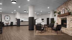 Un vestíbulo amplio con mostrador de recepción, zona de estar y chimenea.
