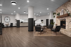 Un vestíbulo amplio con mostrador de recepción, zona de estar y chimenea.