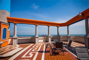 An outdoor terrace with a patterned floor, white columns, and orange railings. - Hotel Candilejas Playa (Veracruz)