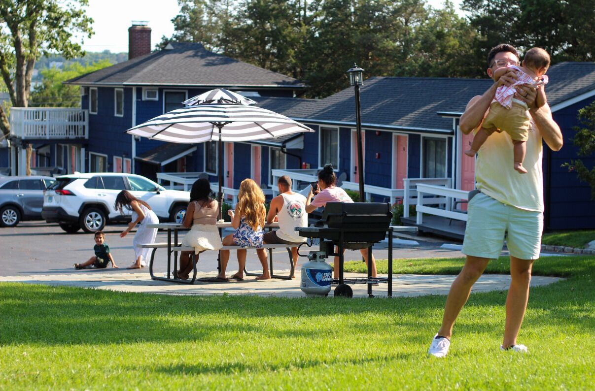 A patio area with outdoor seating, a grill, and a covered umbrella.