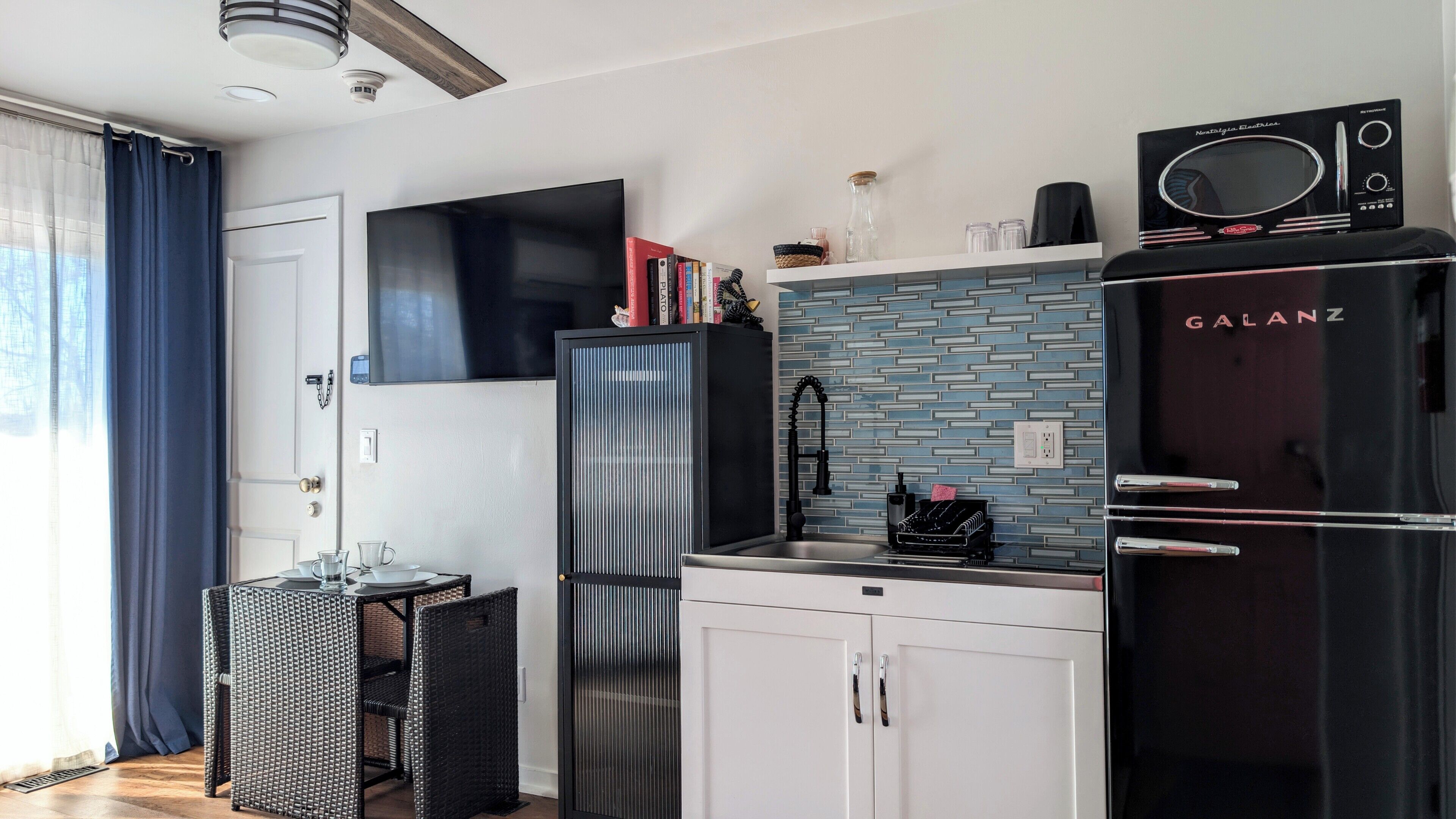 Una cocina compacta equipada con refrigerador, microondas y pileta.