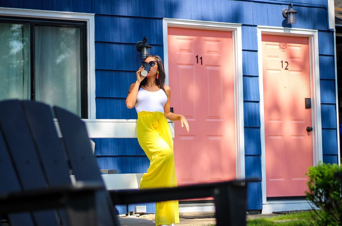 Une personne se tient devant un bâtiment qui a deux portes, l’une portant le numéro 11 et l’autre le numéro 12.