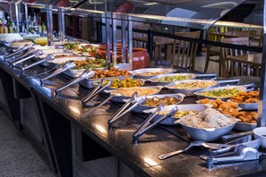A buffet with various dishes and utensils. - Total Hotel (São Paulo)