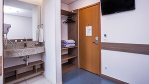 A modern bathroom with a granite sink, towel rack, and a wooden vanity. - Total Hotel (São Paulo)