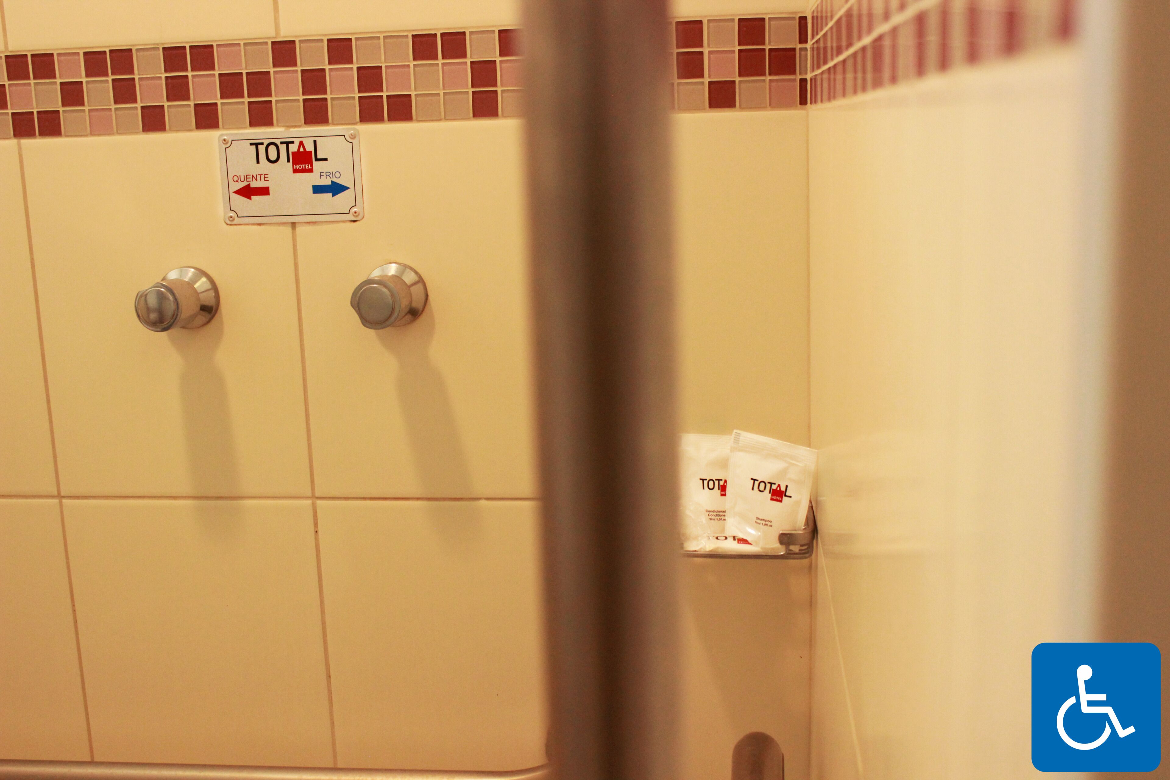 A bathroom with a sign indicating the total number of rooms and a disabled accessibility symbol.
