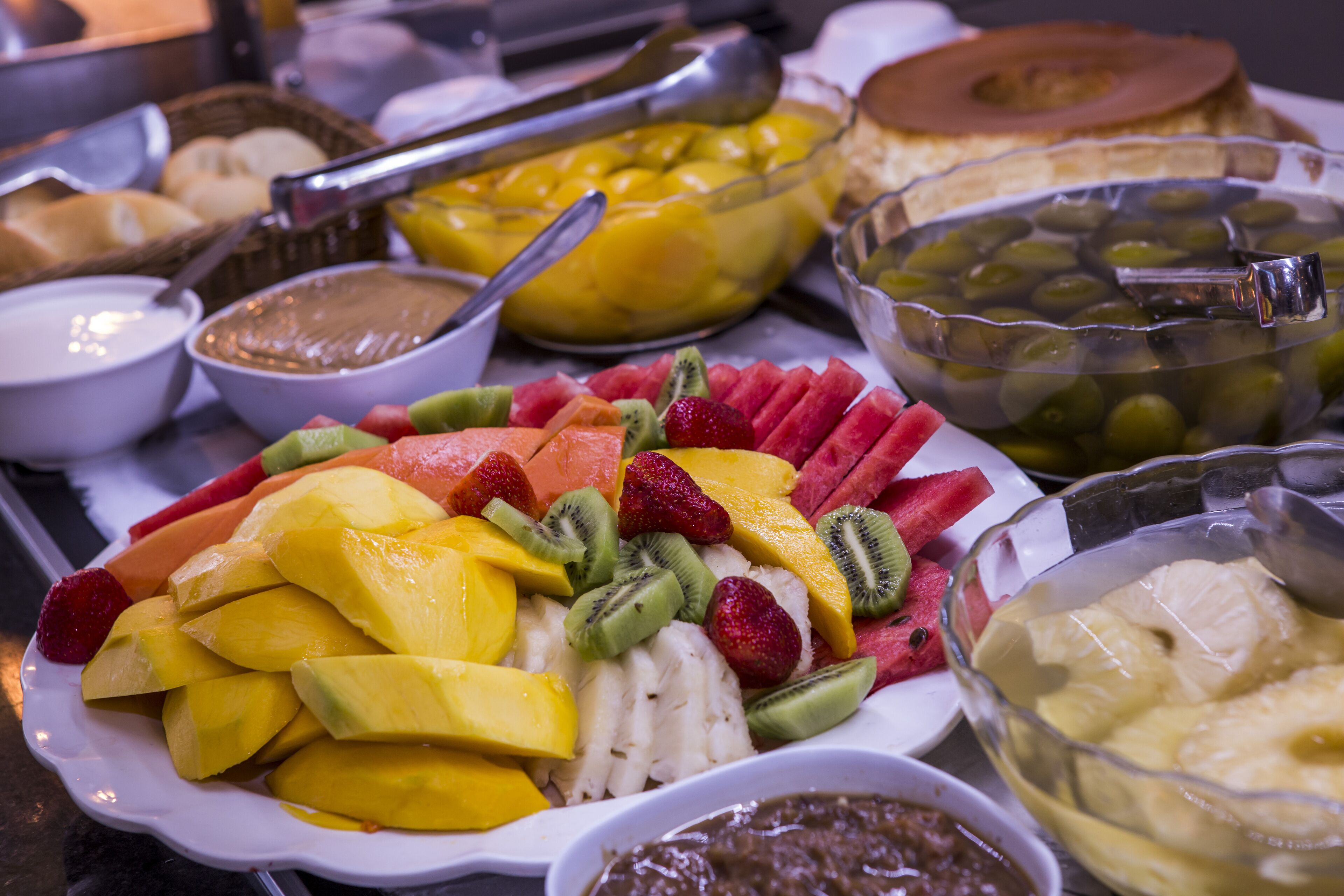 Un bufé con diversas frutas y platos.